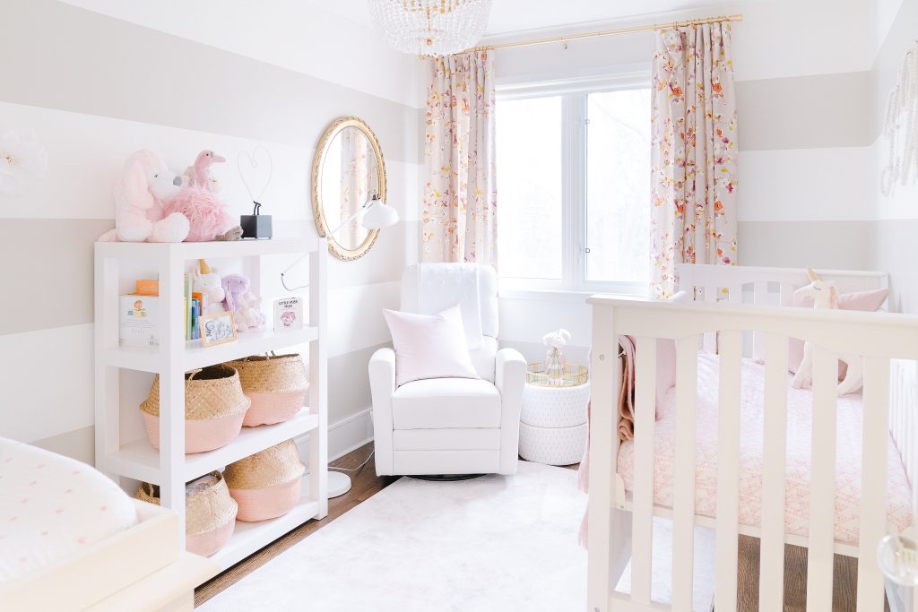 neutral baby girls nursery with striped walls and floral drapes 