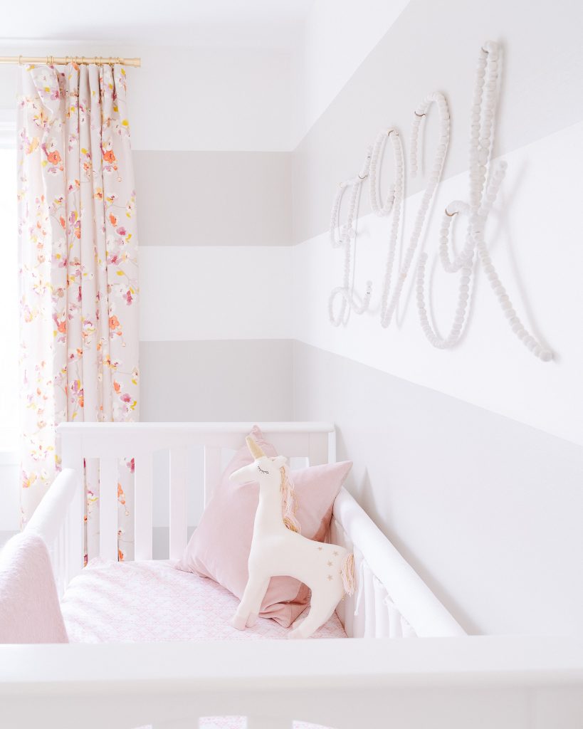 neutral nursery with striped walls and beaded wall letters
